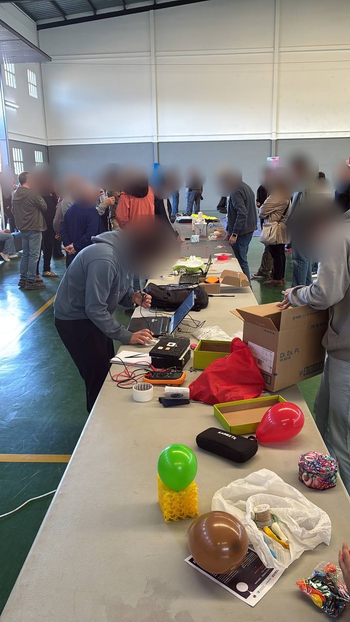 Participants checking their capsules and experiments on a long table in the Lumpiaque sports hall